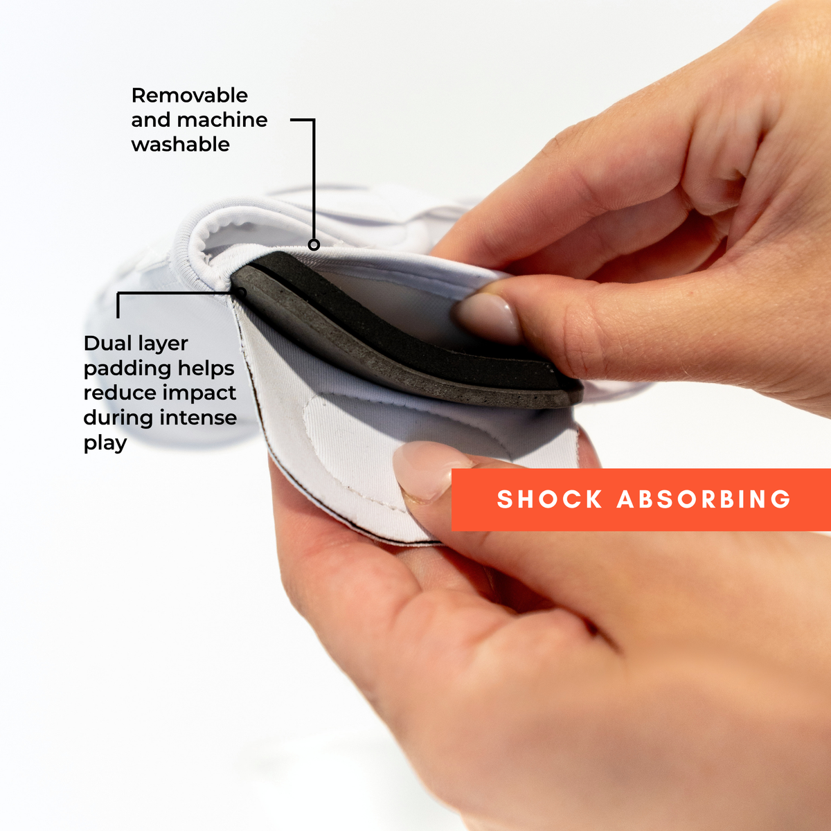 Hands removing dual layer shock absorbing foam insert from knee pad