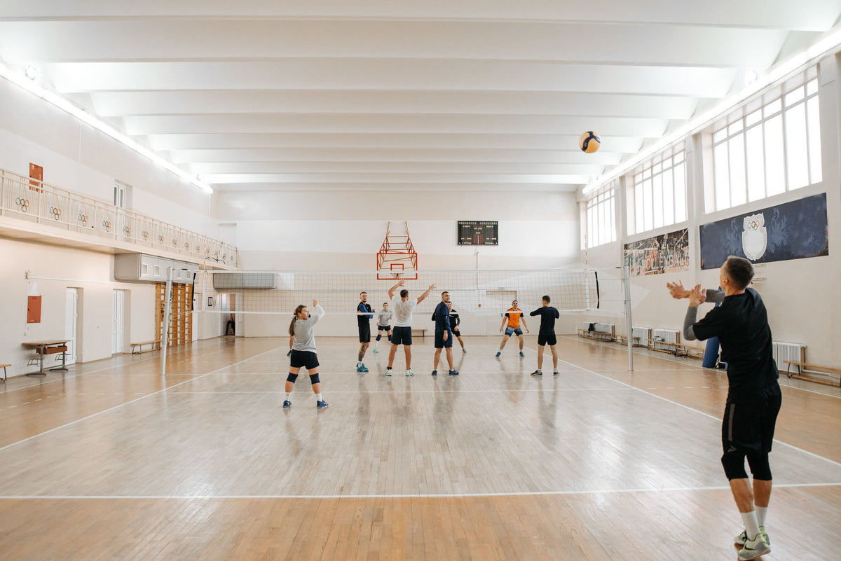 group of adults playing indoor volleyball